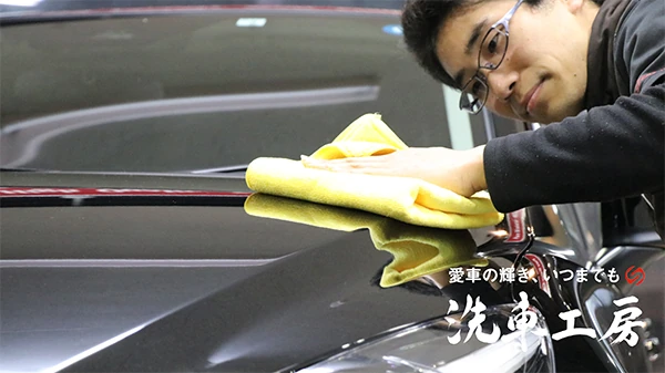 クロスを手に愛車を仕上げる洗車工房の職人